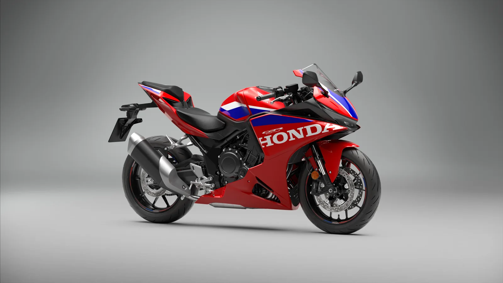 Honda CBR500R FOUR 2027 en decoración roja tricolor, en una fotografía oficial de estudio. No se atribuye una prueba de conducción propia.